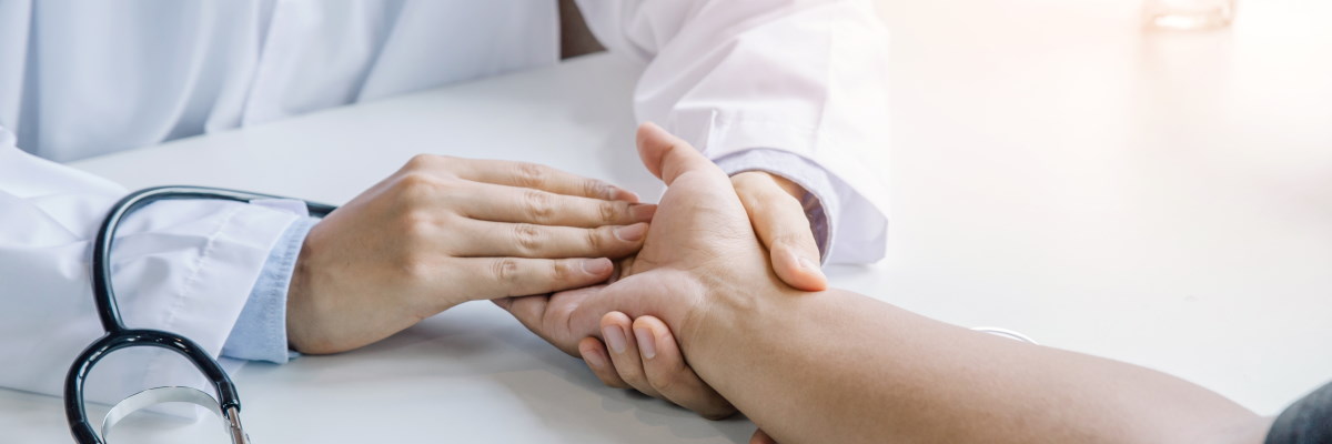 Ein Arzt hält trostspendend die Hand seines Patienten