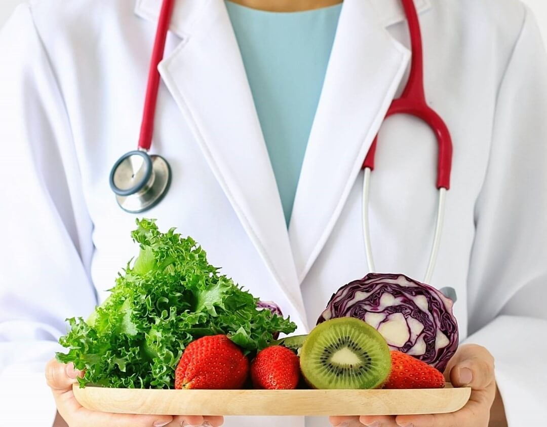 Arzt reicht frische Früchte und Gemüse